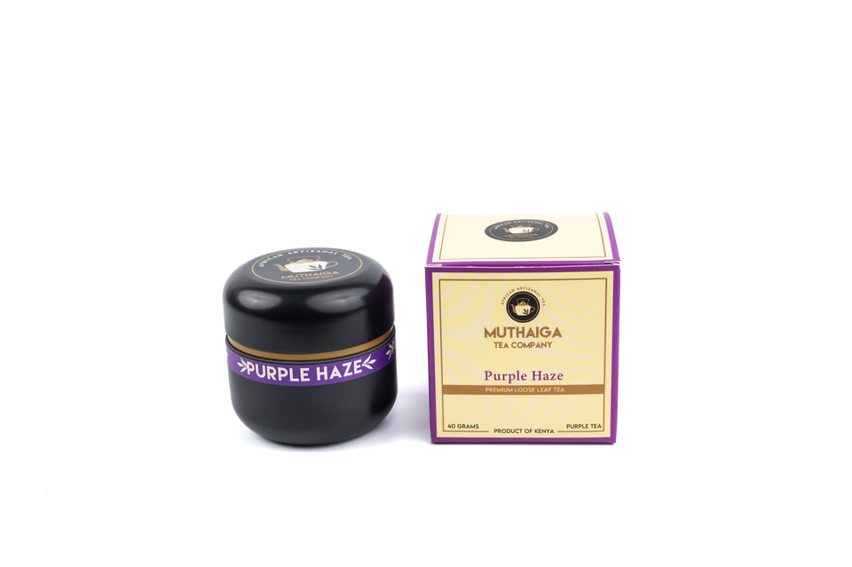 A product image featuring two items, a black container with the label 'Purple Haze' and a decorative box with 'Purple Haze'showcasing the best purple tea in Kenya and the Muthaiga Tea Company logo.