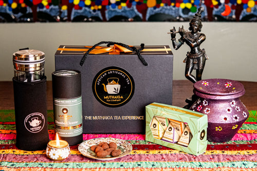 Diwali gift basket set with Muthaiga Tea branding on a colorful tablecloth, showcasing their 6-pack tea taster set, tea tube containing tea bags and water bottle.