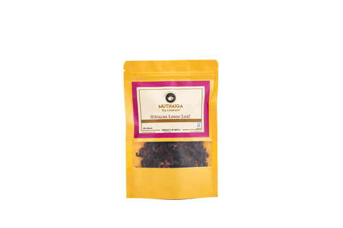 A packaged product of Muthaiga Healthy Hibiscus Tea in Kenya with a yellow label and a transparent window showing the brown hibiscus leaves inside.