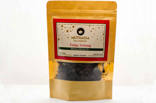 Packaged Loose leaf Oolong tea in Kenya leaves visible through the transparent front of a golden-brown pouch labeled 'MUTHAIGA TEA COMPANY FESTIVE FUDGE OOLONG' with a red and white label.