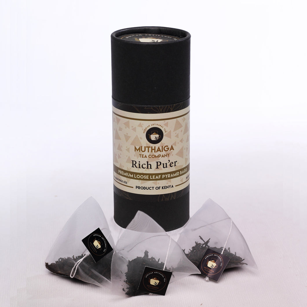 A package of Muthaiga Tea Company,  Rich Pu'er tea bags loose leaf tea accompanied by several silky pyramid tea bags.